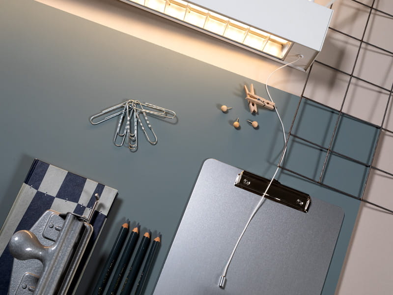 Detaljer fra et kontor. Den blå bakgrunnen er opplyst av Actor Pendant.