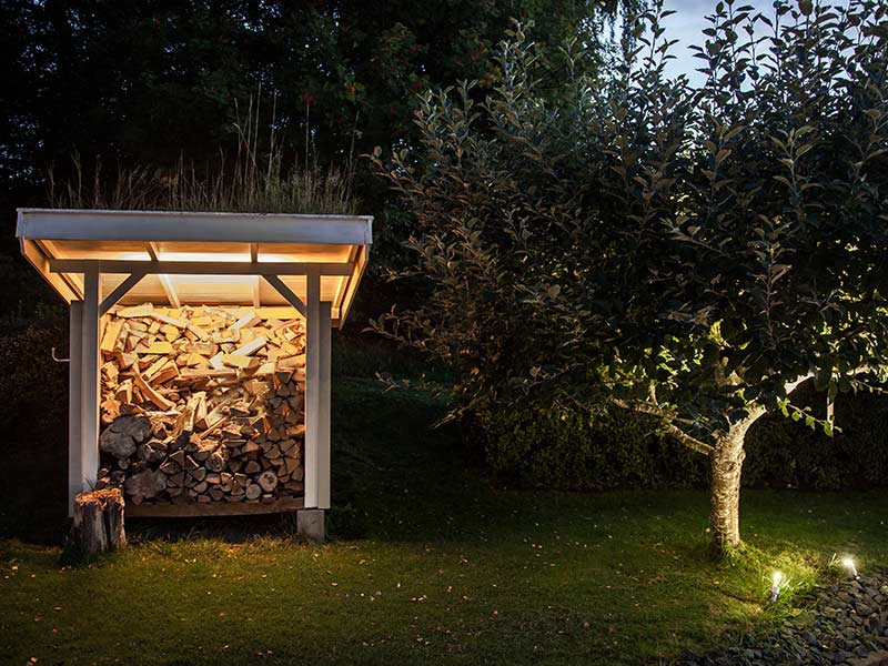 Pihan yksityiskohtien kuten puiden ja varaston valaistus luovat tunnelmaa