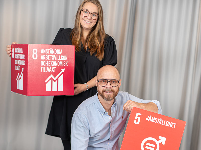 Två personer håller i de globala målen boxar